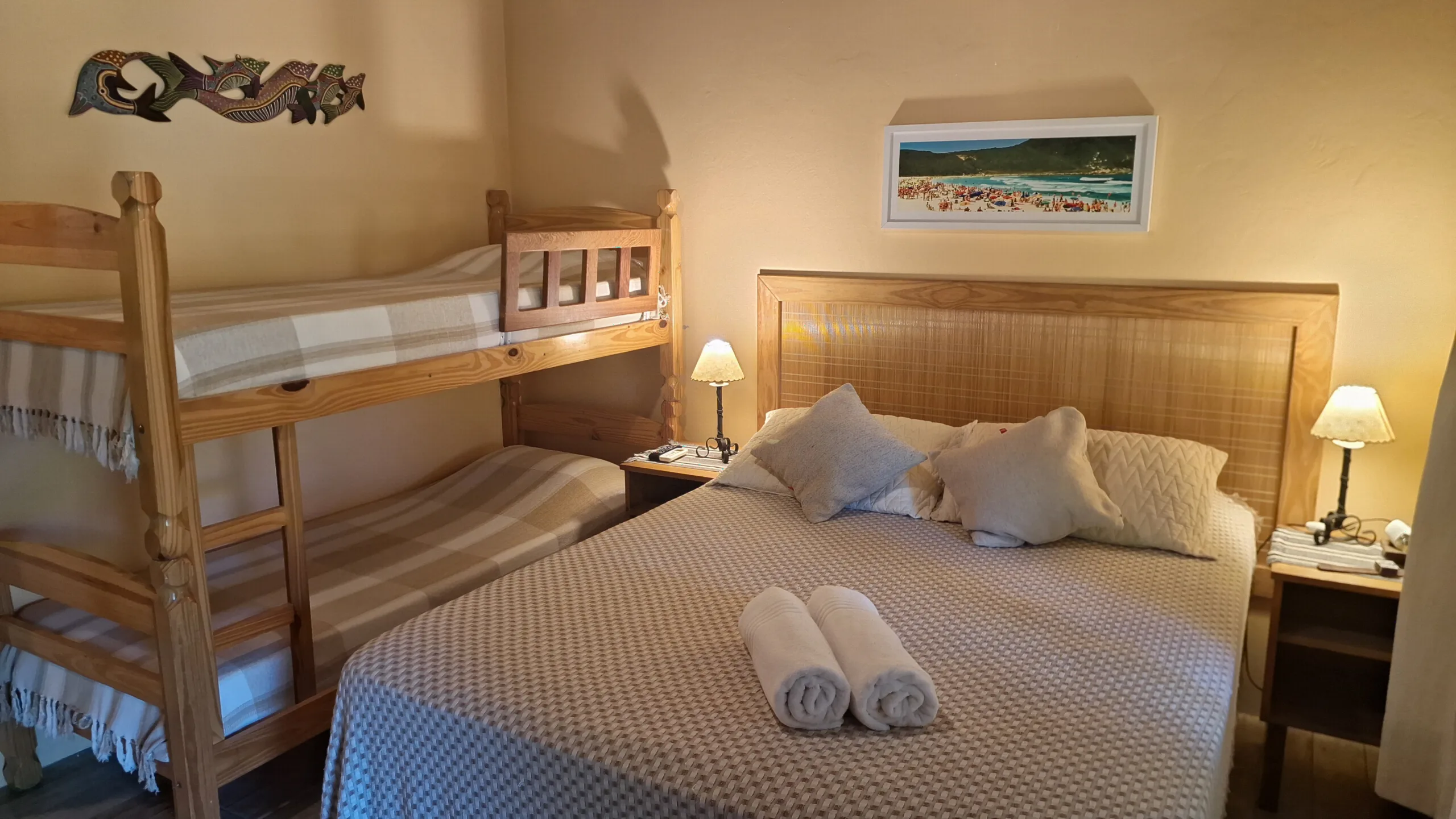 Suíte 9 com cama de casal, beliche de madeira e abajures de cabeceira