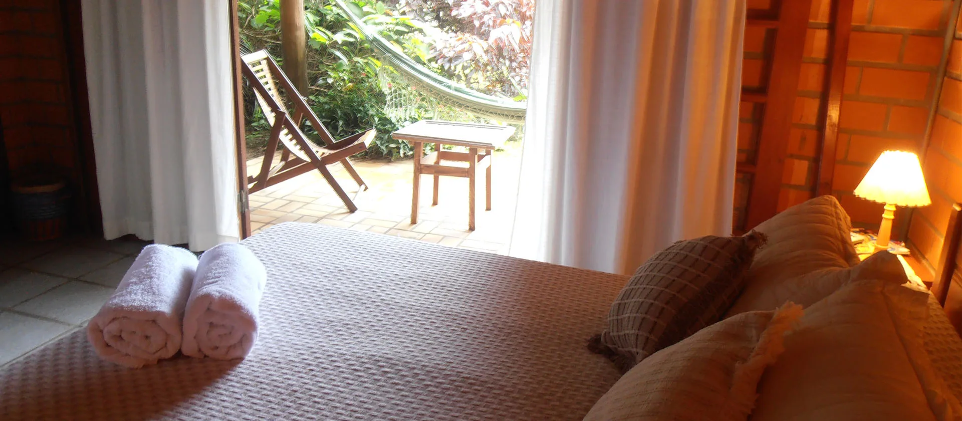 Quarto com toalhas e porta aberta para o deck
